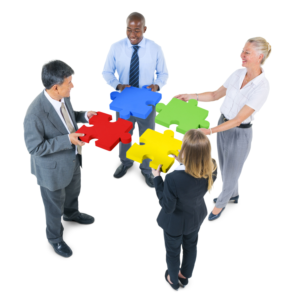 Business Partnership 4 professionals holding puzzle pieces, symbolizing teamwork & engagement