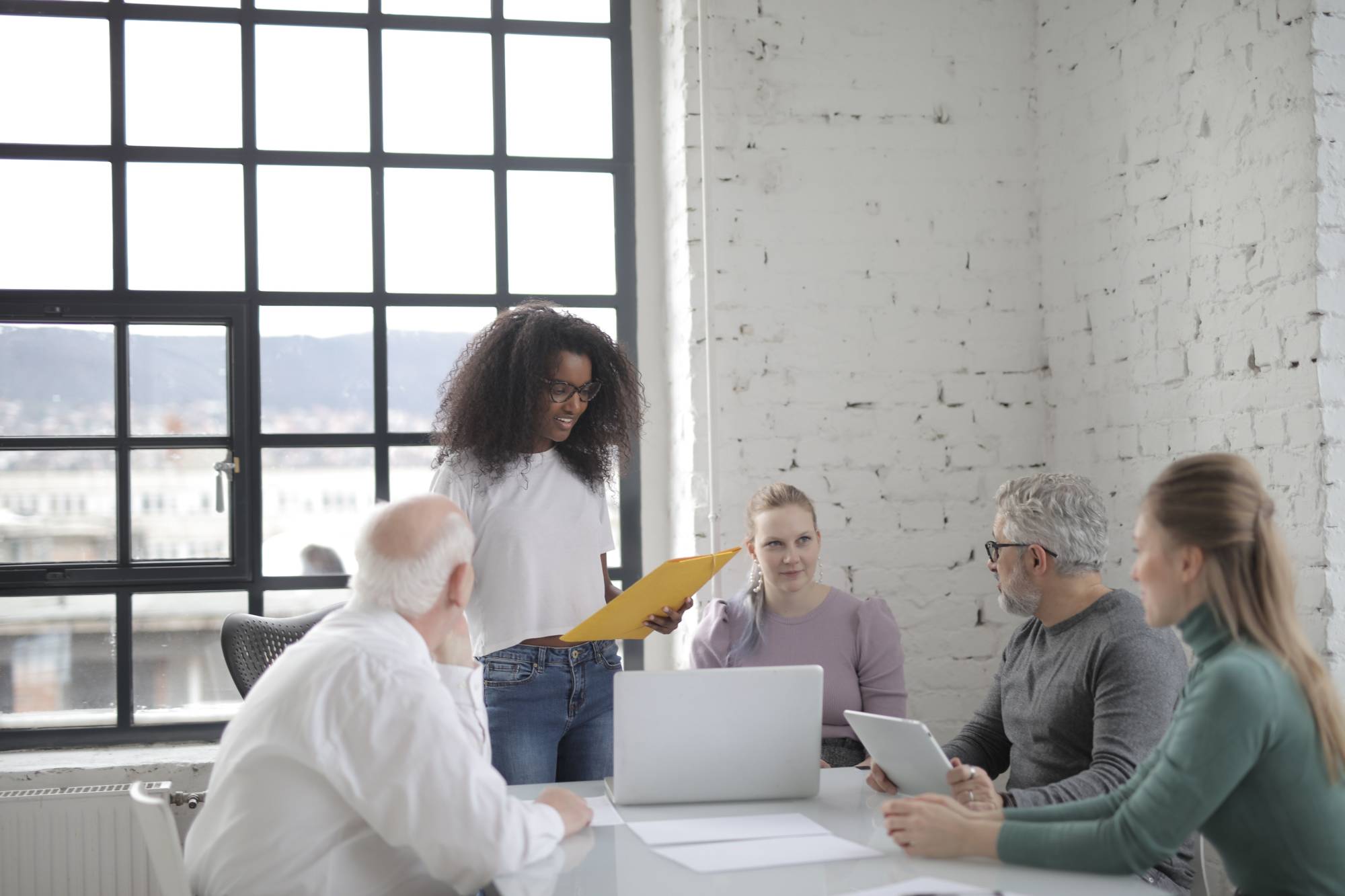 Woman presenting to a group of colleagues in a modern office woman presenting to a group of colleagues in a modern office