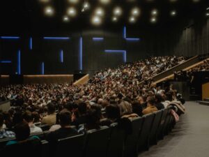 large, modern auditorium filled with a packed audience