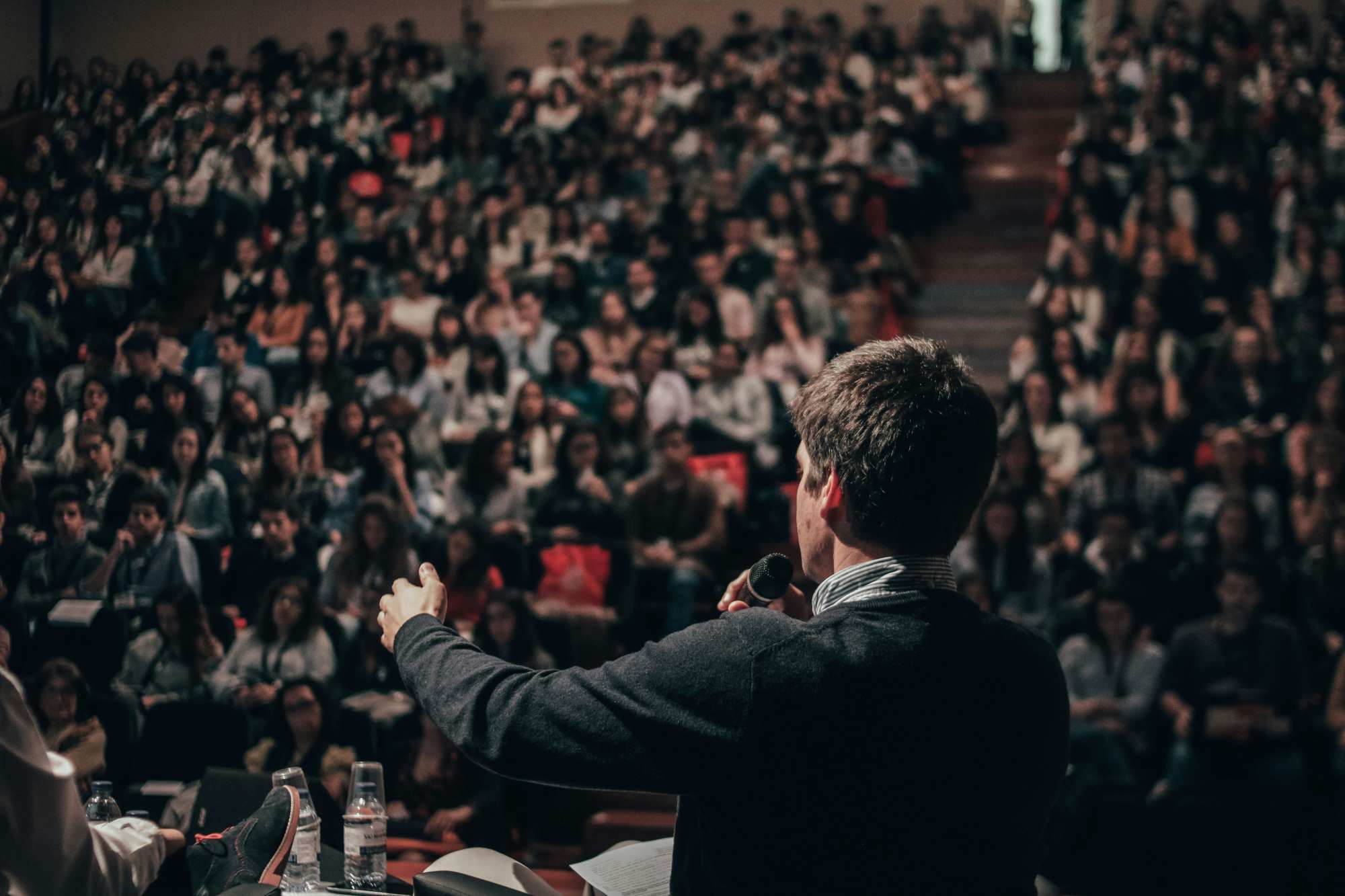 Speaker and Crowd public speaker addressing a large audience in an auditorium